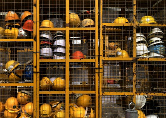 a rack filled with lots of yellow hard hats